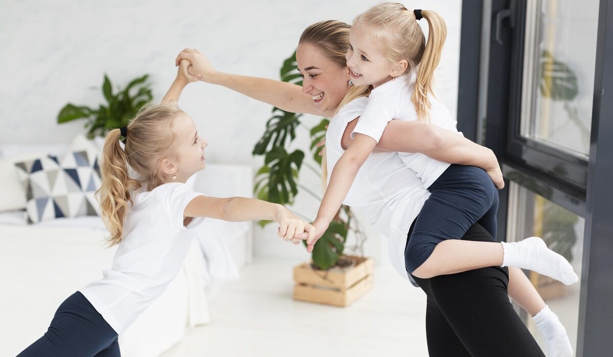 Mama pleše s dvoje djece, nasmijani su i vesele se