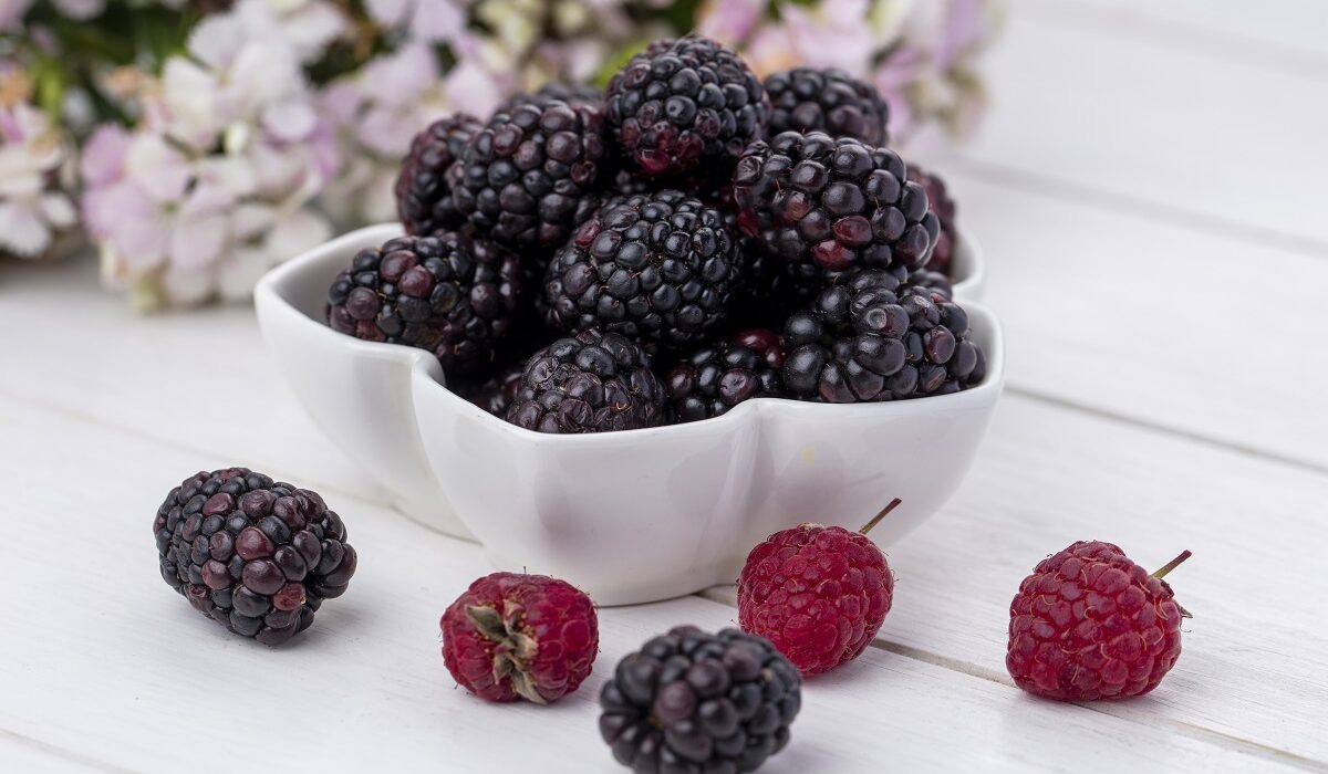 maline i kupine u bijeloj keramičkoj zdjelici na stolu